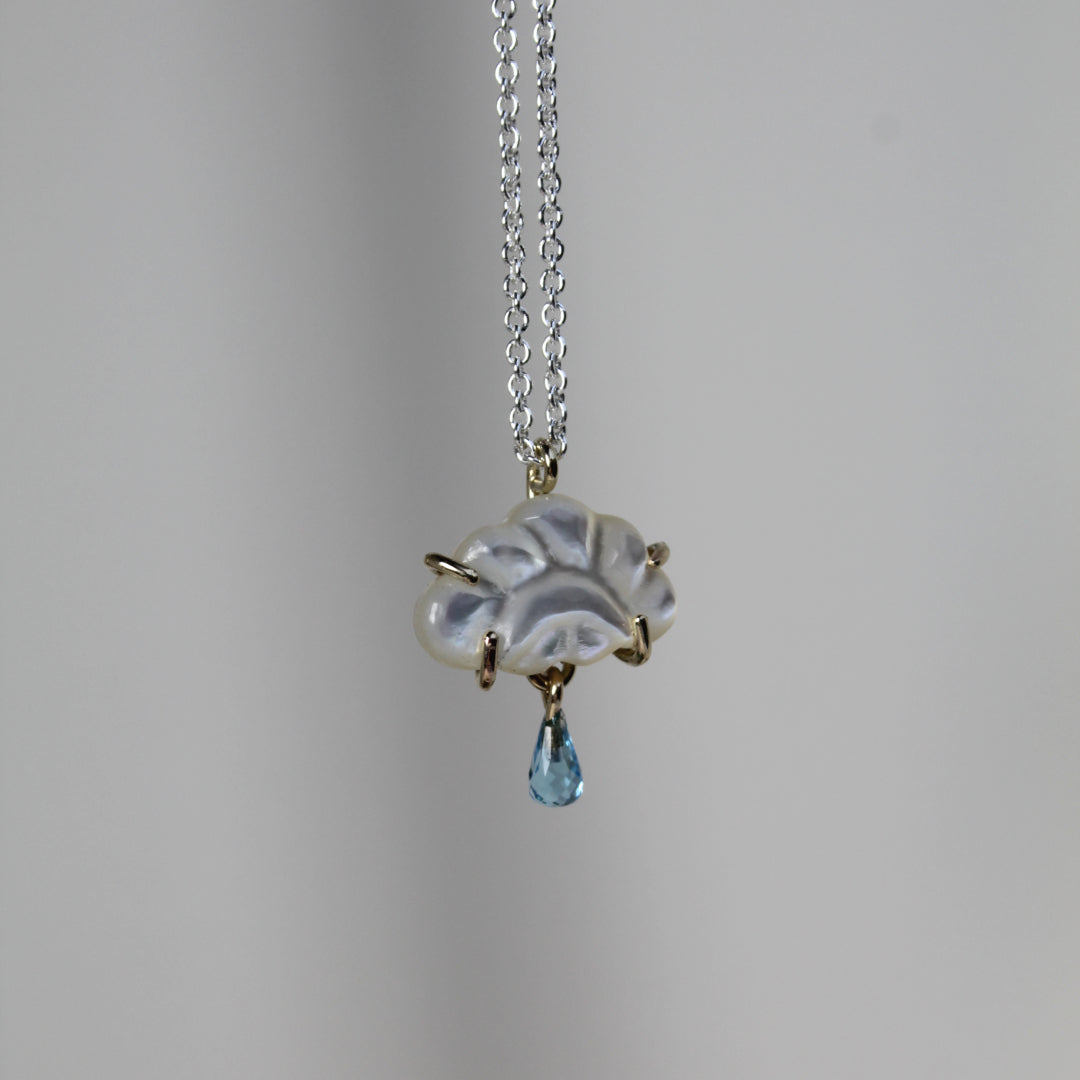 Hanger met parelmoer en topaas. Achter de wolken schijnt de zon.