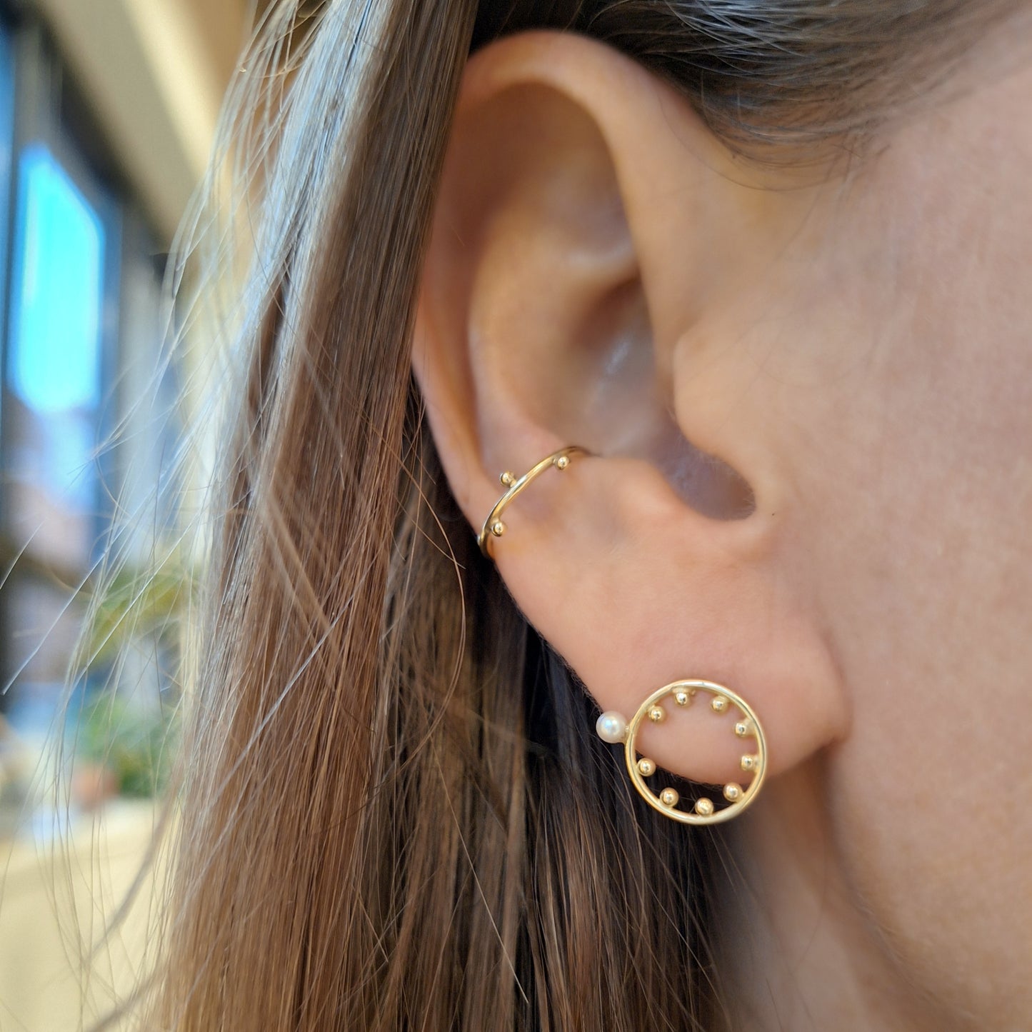 gouden oorbellen in het oor, steker en earcuff