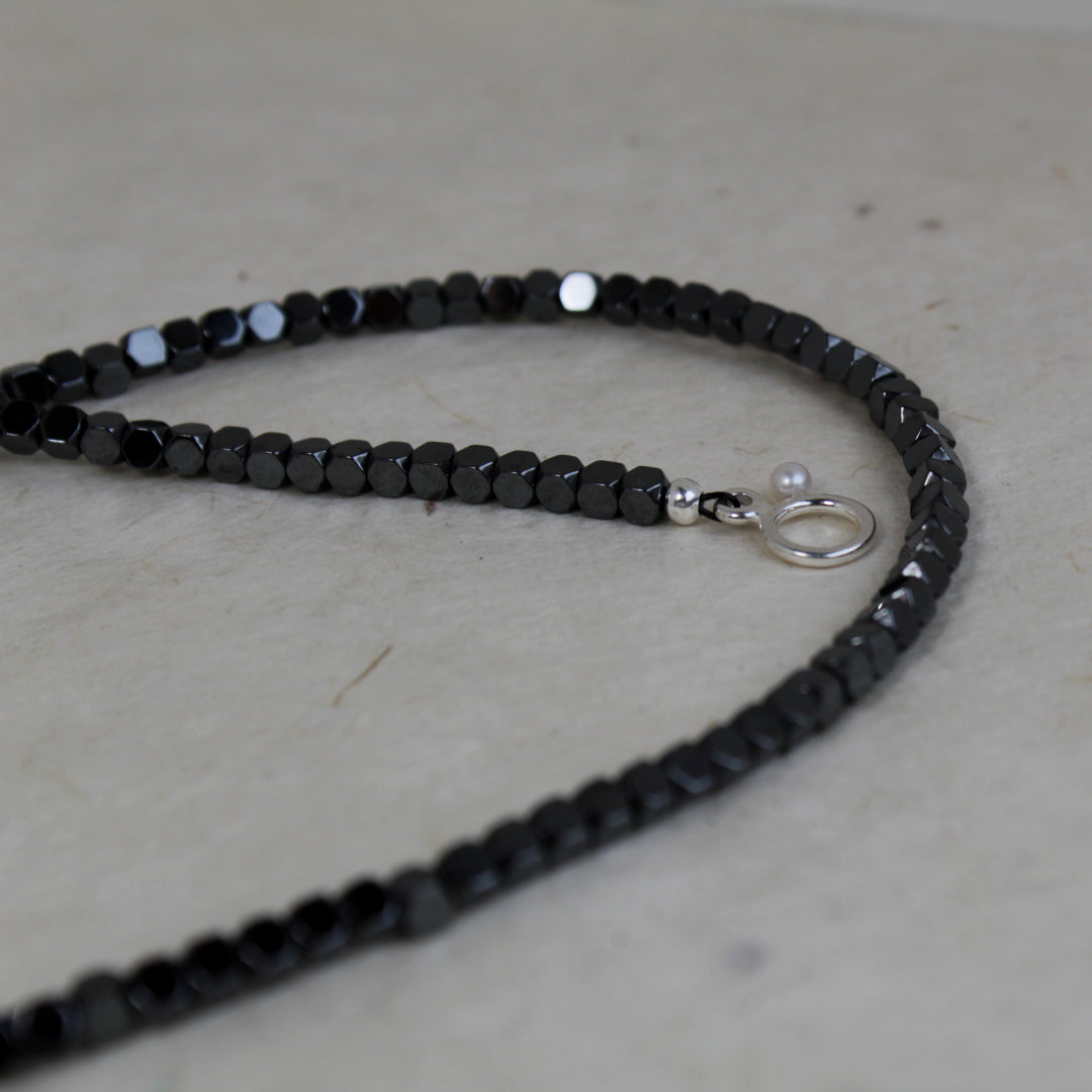 Zwarte edelsteen ketting met zilveren slotje.