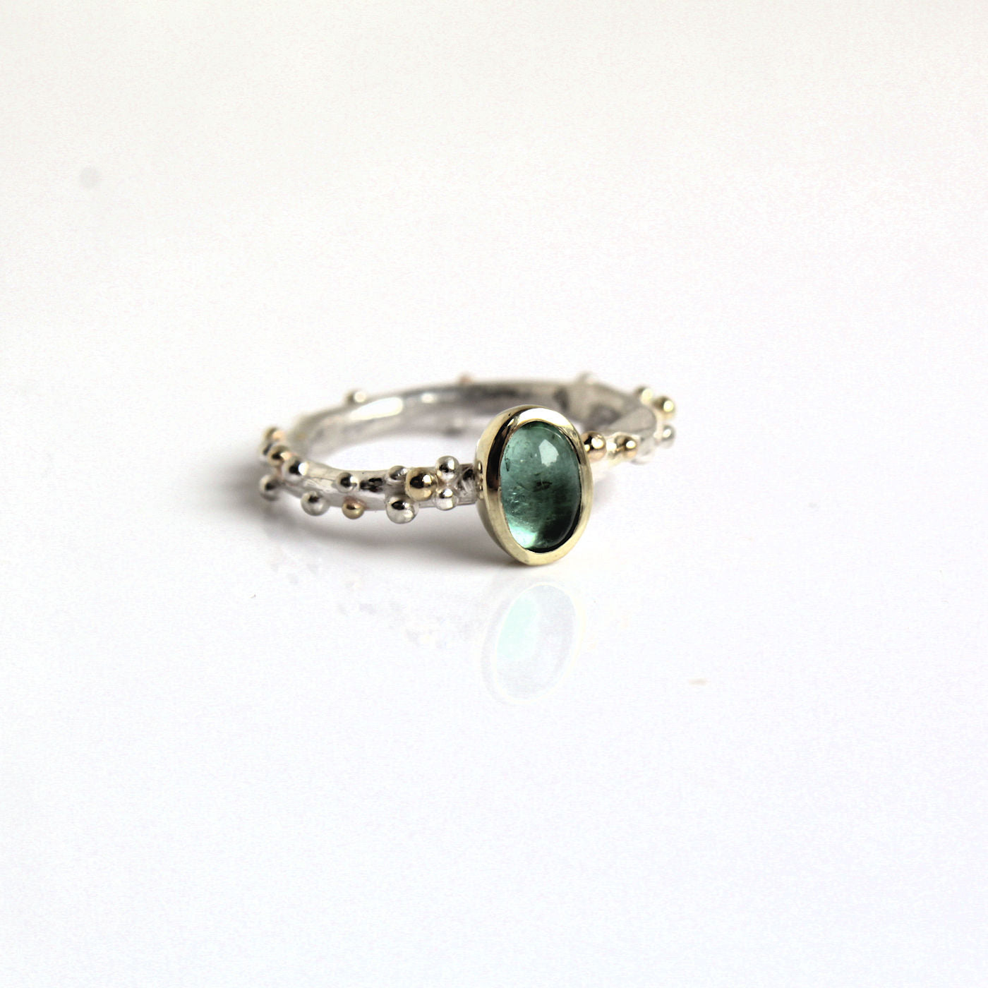 Zilveren ring met goud en toermalijn groenblauw.