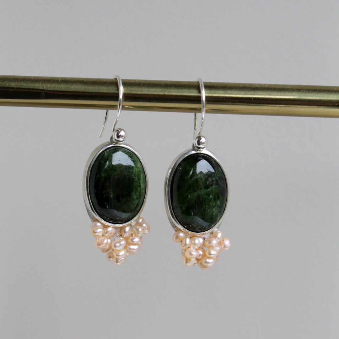 Zilveren oorbellen met groene edelsteen.