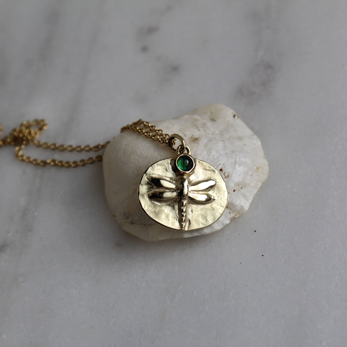 "Change" gouden libelle met smaragd.