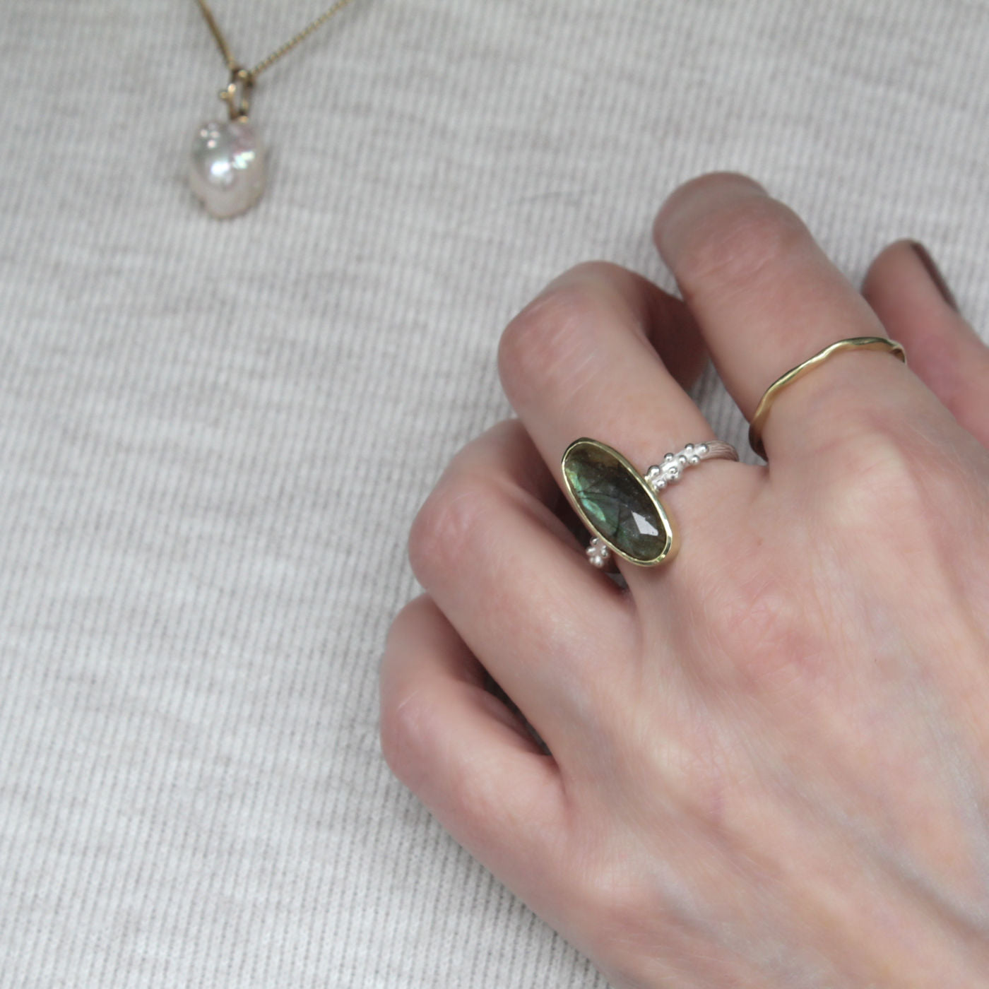 Hand met zilveren ring met Labradoriet.