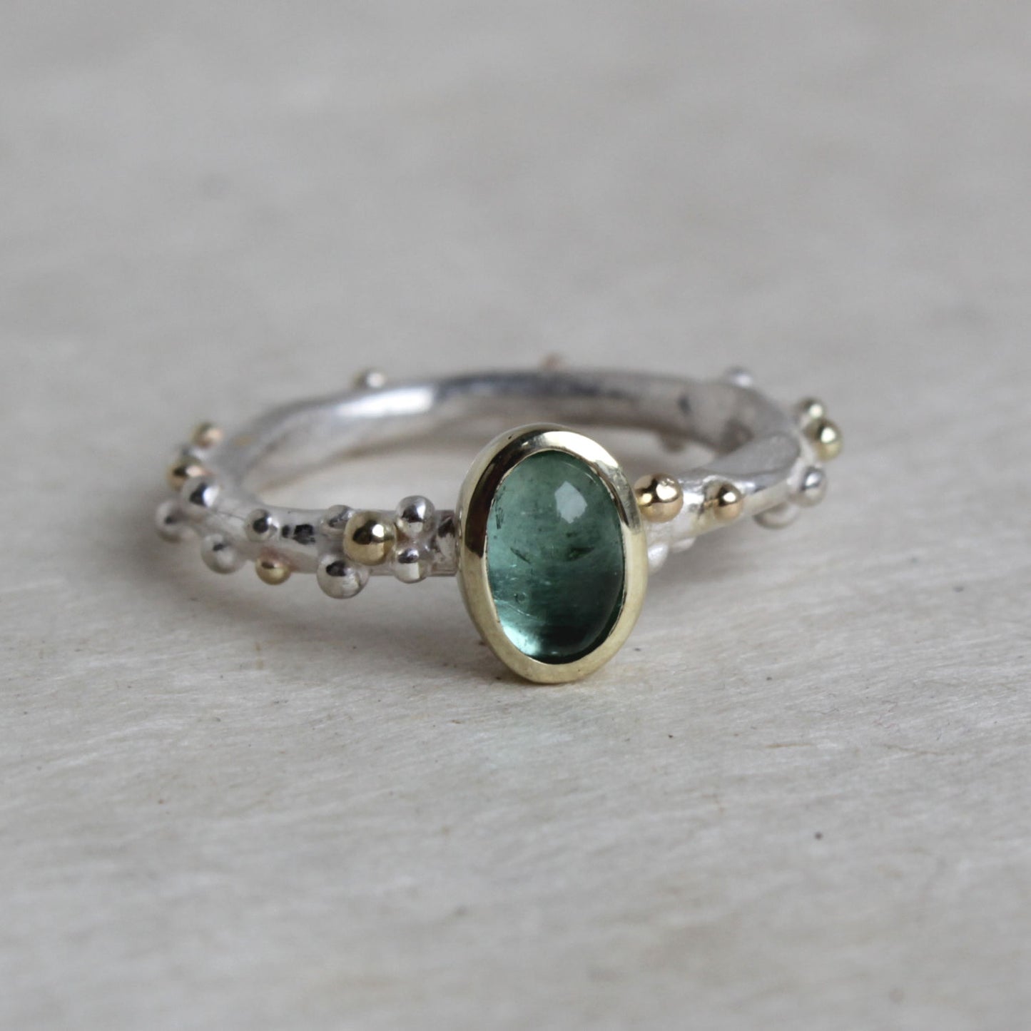 zilveren ring met blauwe toermalijn in gouden kast