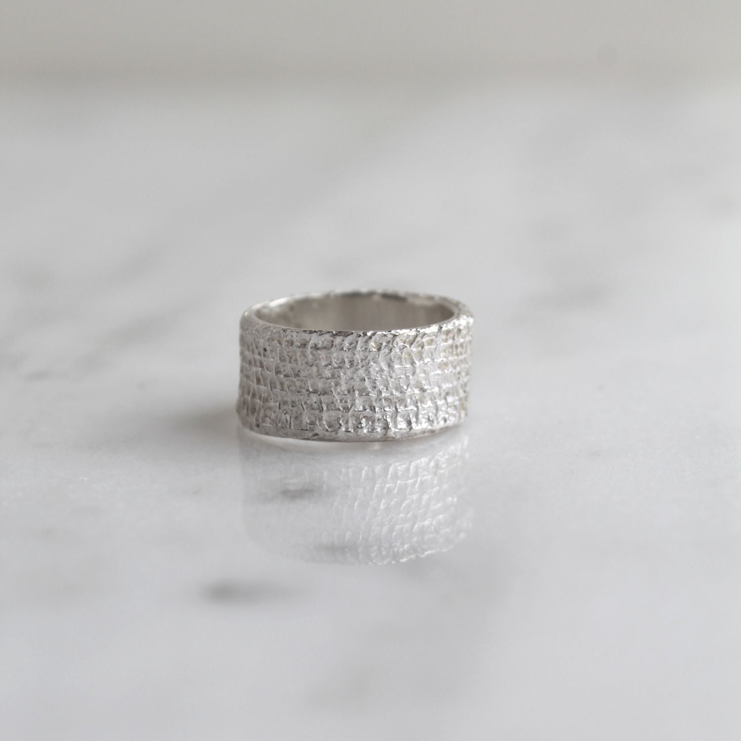 Zilveren ring met de textuur van verband, handgemaakt