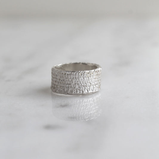 Zilveren ring met de textuur van verband, handgemaakt